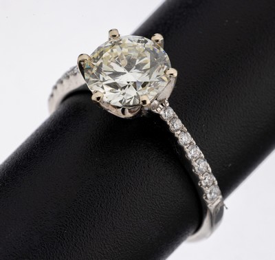 18 kt Gold Brillant-Ring, WG 750/000, mittig Brillant ca. 1.58 ct light Yellow/si, Ringschultern mit Brillanten zus. ca. 0.16 (grav.) feines ...