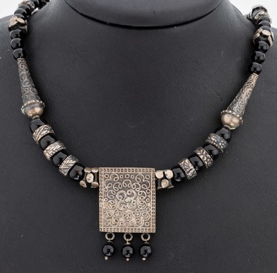 Onyx-Collier, wohl Indien, Silber gepr., rechteckiges Mittelteil mit Arabeskenrelief, Onyx-Kugeln, Zwischenglieder in versch. Formen, L. ca. 49 cm, ...