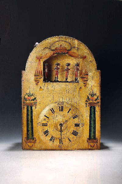 Sog. Flötenuhr mit Automat, Schwarzwald, um 1820/30, großes bemaltes Bogenzifferblatt, im Arkus 4 z.T. bewegliche Figuren (eine Figur unvollst.) ...