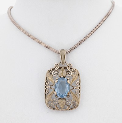 Farbstein-Anhänger, wohl Pforzheim, um 1920- 30, 900er Silber, mittig ovalfacett. blauersynth. Spinell, Fassung druchbrochen mit Voluten und ...