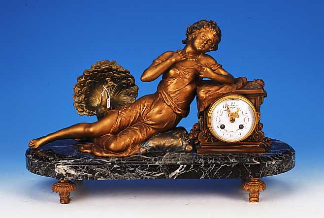 Pendule, Frankreich, um 1910/20, grnge„- derter Marmorsockel, verzierte Fáe, Uhr flankiert von liegendem M„dchen vor radschla- ...