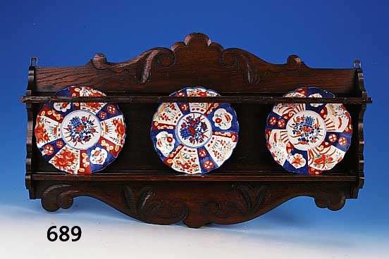 Wandregal, deutsch, um 1900, Eiche mit Flachschnitzereien, ca. 44 x 80 cm, dazu drei japanische Porzellanteller mit Felder- bemalung in ...
