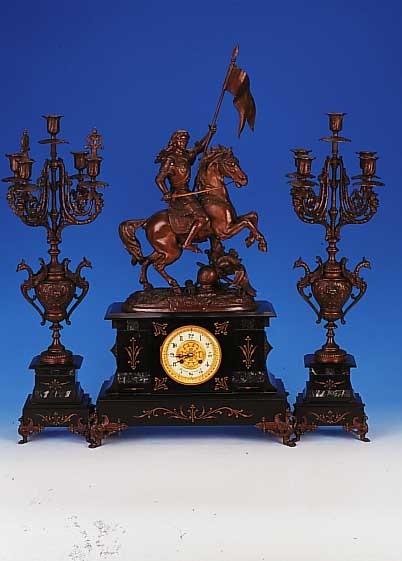 Groáe Kaminuhr, mit zwei groáen Kerzenbeistel-lern, Frankreich, um 1900, schwarzer Schie- fersockel mit Ornamenten, Messingfáe patin., seitl. ...