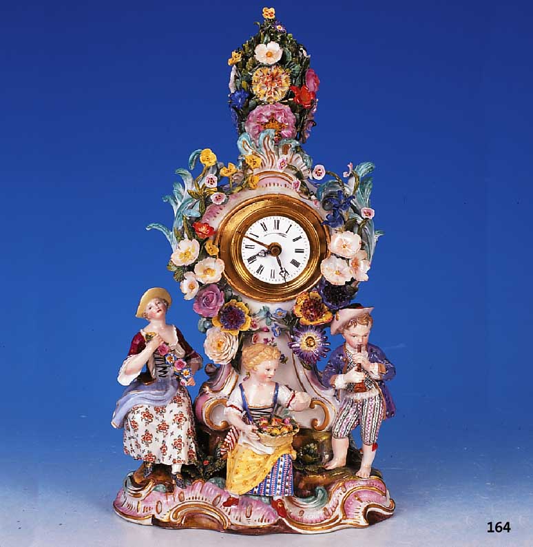 Pendule, Meissen, um 1860, Porzellan, mit drei vollplastischen Figuren und reichen Applikationen von bunten Blüten, teilrest. an Blüten, ...