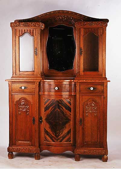 Aufsatzbuffet, wohl Flandern, um 1930, Eichefurnier, mit Marmorplatte, z.T. Wurzel- furnier, Oberteil verglast und verspiegelt, geschnitzter ...