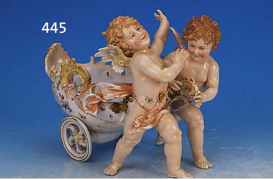 PORZELLANSKULPTUR, DEUTSCH, UM 1900, ZWEI VOLLPLASTISCHE PUTTI ZIEHEN EINE SCHALE IN FORM EINER KUTSCHE, REICH RELIEFIERT U. MIT ROCAILLEN ...
