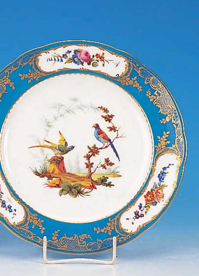 Teller, Sèvres, um 1780/90, Weichporzellan, blauer Rand mit Golddekor und Blumenmalerei inKartuschen, mittig feine bunte Malerei von exotischen ...