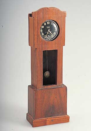 TASCHENUHRSTäNDER IN FORM EINER MINIATURSTAND-UHR, EINGESCH. WEST-CLOX-TASCHENUHR M. STIF-TENANKERWERK, METALLGEH. VERCHR., D. CA. 50 MM, ...