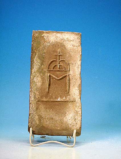 Ofen- oder Gewölbestein, süddeutsch, 16./17. Jh., Schamott, mit reliefiertem Hohheitszei-chen (stil. Krone über M), ca. 27,5 x 14 x 4 cm