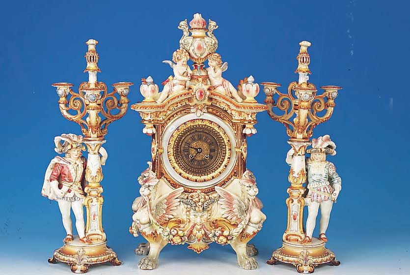 PRUNKPENDULE MIT ZWEI BEISTELLERN, GUSTAV BECKER, UM 1895, REICH VERZIERTES KERAMIK- GEHäUSE, FISCHER & FISCHER MüNCHEN, FüßE IN FORM VON ...
