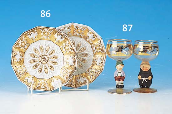 VIER GLäSER, DEUTSCH, 50ER JAHRE, FARB- LOSES GLAS MIT GESCHLIFFENEM WEINLAUBDEKOR, STIELE PORZELLAN IN FORM VON FIGUREN, H. JE CA. 14 CM.