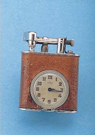 ELBA BENZINFEUERZEUG MIT EINGEBAUTER UHR, MESSING VERCHR., MITTELTEIL LEDERBEZ., SCHWEIZUM 1935, ZYLINDERRUNDWERK, GEHFäHIG/INTAKT, MAßE CA. ...