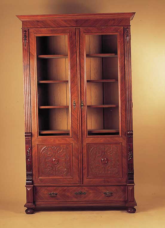 Bücherschrank, deutsch, um 1890, Nußbaumfurnier, geschnitzte Kassetten, Ein- legeböden, Sockelschub, 222 x 130 x 45 cm, ...