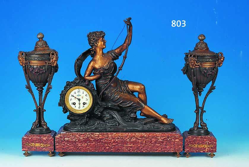 KAMINUHR MIT ZWEI BEISTELLERN, FRANKREICH, UM 1920, ROT GEäDERTER MARMORSOCKEL, METALLGUß-BEKRöNUNG IN FORM DER GöTTIN DIANA MIT BOGEN UND ...