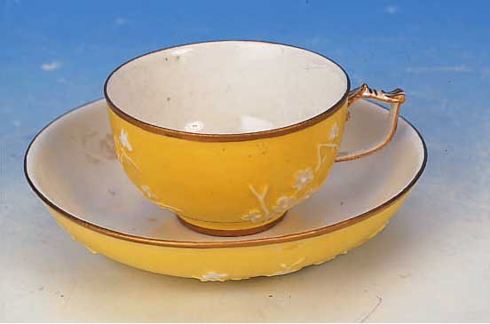 TASSE MIT UNTERTASSE, MEISSEN, UM 1720-25, PORZELLAN, GELBER FOND, MIT WEIßEM TEILRELIE- FIERTEM BLUMENDEKOR, GOLDSTAFFAGE, TASSENH. 5 CM; D. ...