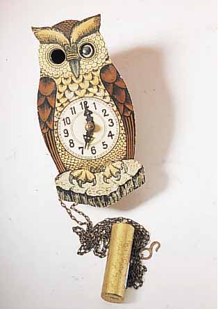 WANDUHR SCHILD IN FORM EINER EULE, SOGEN. AUGENWENDER, 1-TAGESWERK, HOLZ LACKIERT, HAR- KENHEMMUNG M. SEKLETT. WERK, DEUTSCHLAND UM 1950, H. CA. ...