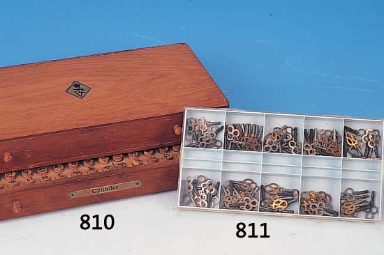 FURNITUREN FüR UHRMACHER, RUD. FLUME, UM 1930, HOLZKASTEN MIT 2 LADEN, GEFüLLT MIT TUBEN, INHALT CA. 215 ZYLINDER, 200 UNRUH- WELLEN, ...