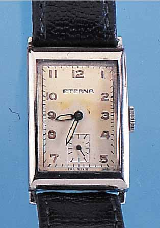 ETERNA HERRENARMBANDUHR, EDELST.-RECTANG.- FORM, BODEN AUFGEDR., IN SICH L. GEWöLBT, ORIG. BLATT ALTERSBED. FARBL. GET., ANKERFORM-WERK, ...