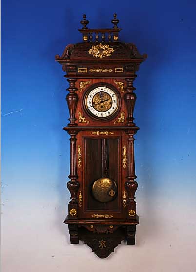 WANDUHR MIT VIERTELSTUNDENSCHLAG, KIENZLE, UM 1900, REICH VERZIERTES U. GESCHNITZTES HOLZ-GEHäUSE, MIT MESSINGAPPLIKEN BESETZT, ORIGI- NALAUFSATZ, ...