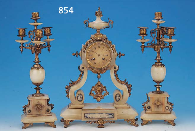 KAMINUHR MIT ZWEI BEISTELLERN, FRANKREICH, UM 1900, VERZIERTES ALABASTERGEHäUSE MIT MES- SINGGUßAPPLIKATIONEN BESETZT, DREI BEMALTE KARTUSCHEN ...