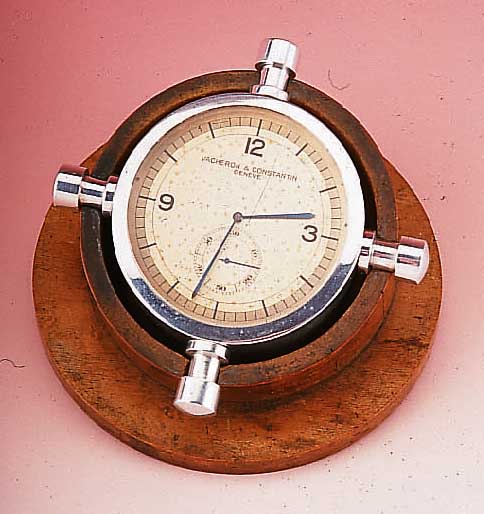VACHERON & CONSTANTIN TISCHUHR CHRONOMETRE ROYAL, REF.-NR. 368517, SCHWEIZ UM 1930, ALUMINIUM POL., AUF WURZELHOLZSTäNDER IN PULTFORM, ...