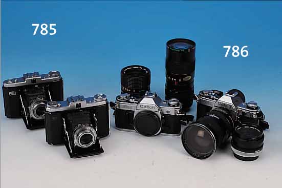 KONVOLUT: ZWEI CANON AE-1; BEI EINEM GEHäUSE IST DER BATTERIEFACHDECKEL ABGEBROCHEN ABER VORHANDEN; DAZU CANON FD50MM 1:1.8, ...