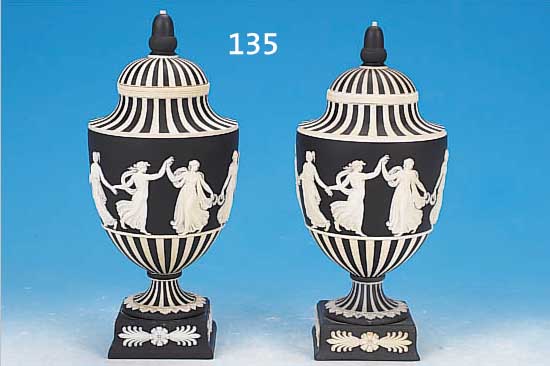 ZWEI DECKELPOKALVASEN, WEDGWOOD, BISQUITPOR-ZELLAN, UMLAUFENDER FRIES, RELIEFIERTER DEKOR AUF SCHWARZEM GRUND, ANTIKISIERENDE DARST. ...