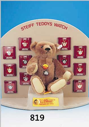GR. PRäSENTATIONSDISPLAY, STEIFF TEDDYS WATCH 1993, 12 STEIFF-UHREN IN FORM VON BäREN- KöPFCHEN, IN VERSCHIED. AUSFüHRUNGEN AN KETTE,IN DER ...