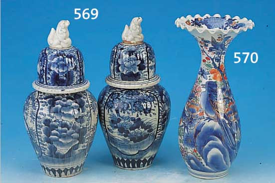 ZWEI DECKELVASEN, JAPAN, UM 1830, STEINGUT, BLAUE FLORALE BEMALUNG, BEKRöNUNG IN FORM JE EINES FO-HUNDES, H. CA. 34 CM, L. ALTERSSP.