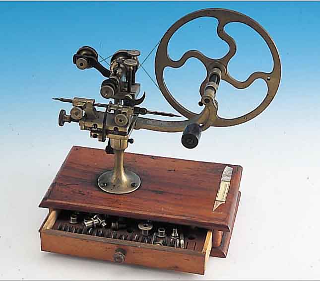 UHRMACHERWERKZEUG: PRäZISIONSRäDERFRäSMA- SCHINE, UM 1910, AUF HOLZKASTEN, FRäSEINS. U. HALTEBROSCHEN FAST VOLLSTäNDIG VORHANDEN, M. GER. ...