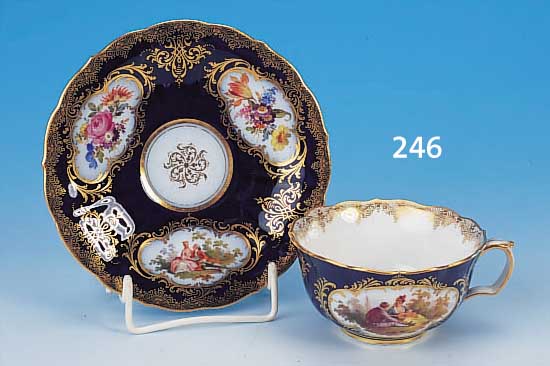 TASSE MIT UNTERTASSE, MEISSEN, UM 1880/90, PORZELLAN, KOBALTBLAU GLASIERT, IN INSGESAMT 5 GOLDGERAHMTEN KARTUSCHEN FEINE BUNTE BLUMEN-MALEREI UND ...