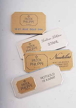 SET: 4 UHRENPRäSENTATIONSSCHILDER VON PATEK PHILIPPE, METALL, Z.T. GOLDFARB., 1 X FüR NAUTILUS, 1 X FüR GOLDENE ELLIPSE, 1 X FüR 18 CT ...