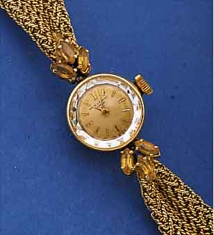 BAUME & MERCIER DAMENSCHMUCKBANDUHR, REF.- NR. 31672, SCHWEIZ UM 1966, GG 750/000 INCL. GG-BAND, GEFLOCHTEN ZU DEN M. TOPASEN BEL. BANDANST. ...