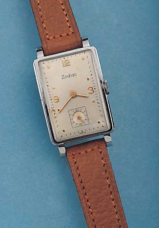 ZODIAC HERRENARMBANDUHR, SCHWEIZ UM 1938, METALL, RECT.-FORM HARTVERCHR., EDELST.-BODEN IN SICH GEW., KONKAVGL., VERS. BLATT, ZUM RAND ZU L. ...