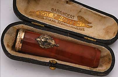ZIGARRENSPITZE MIT BERNSTEIN, STAATLICHE BERNSTEINWERKE 1936/1939, RAND METALL ROT- VERGOLDET, AUFGEL. KARTUSCHE FüR MONOGR. VERG., IM ...