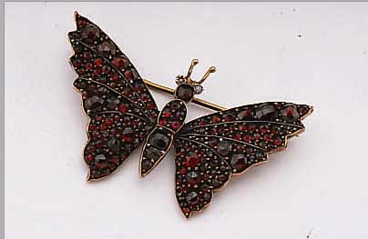 BROSCHE MIT GRANATEN IN FORM EINES SCHMETTER- LINGS, BöHMEN UM 1900, PERLCHENBESATZ, METALL VERGOLDET, NADELUNG SEK. VERäNDERT
