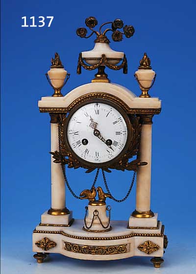 KAMINUHR, FRANKREICH UM 1880, MARMORGEHäUSE MIT VERZIERTEN MESSINGAPPLIKATIONEN, FLORALE BEKRöNUNG, IM SOCKEL 2 TAUBEN, 2 VOLLSäULEN, MIT ...