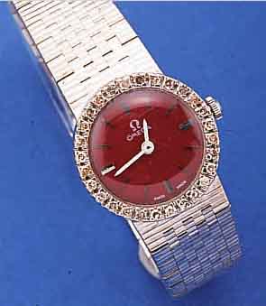 OMEGA DAMENGOLDBANDUHR, SCHWEIZ UM 1968, NEUTR. WG 750/000 INCL. WG-BAND, LÜNETTE M. DIAMANTEN, TEILW. KL. KERBEN/BESCH., BODEN GEDR., ...