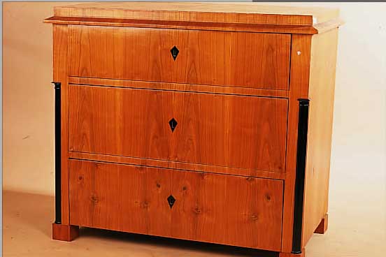 KOMMODE, ENDE 20. JH., IM STIL VON 1830, KIRSCHBAUM FURNIERT, SCHWARZ GELACKTE HALB- SäULEN, DREI SCHüBE, ALTERSBEDINGTE GEBRAUCHS-SPUREN, ...