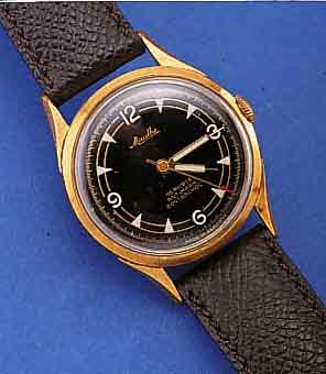 MAUTHE/VW HERRENARMBANDUHR, DEUTSCHLAND UM 1962, METALL HARTVERG., AUF EDELST.-SCHR.- BODEN SONDERGRAV. FüR 100.000 GEFAHRENE KM, AUßER ...