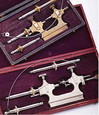 KONVOLUT: UHRMACHERWERKZEUG, 2 ZAPFENROL- LIERMASCHINCHEN IM ETUI, BEIDE M. SOGEN. FIEDELBOGEN, NUTZSP., BEIDE UM 1914, EINSäTZE NICHT ...