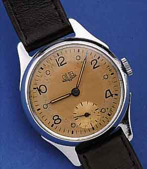 GUB HERRENARMBANDUHR, REF.-NR. 19473, DEUTSCHLAND UM 1953, METALLGEH. NACHVERCHR., EDELST.-BODEN U. GLASR. GEDR., ORIG.-BLATT FL., KAL. ...
