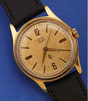 GUB HERRENARMBANDUHR, REF.-NR. 618240, DEUTSCHLAND UM 1958, METALL VERG., EDELST.- BODEN GESCHR., ORIG.-BLATT FL., GüTEZEICHEN, LEDERB. ...