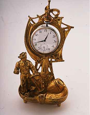 UHRENSTäNDER DARSTELLUNG HOLLäNDER MIT SEGEL- SCHIFF, MESSINGGUß VERG., UM 1910, BER., H. CA. 16 CM, ANBEI TASCHENUHR, WERK SIGN. HENRY ...