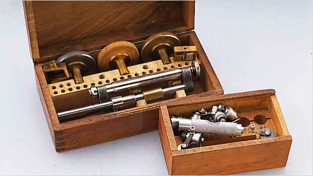 KONVOLUT UHRMACHERWERKZEUG: 1X SCHR.-KOPF- POLIERMASCHINE IM HOLZKASTEN UM 1950, 1X FEDERWINDER FüR ARMBAND- U. TASCHENUHREN (CA. 7-14 ...