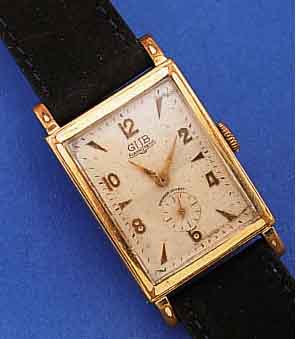 GUB HERRENARMBANDUHR, REF.-NR. 98725, DEUTSCHLAND UM 1958, METALL VERCHR., BER., EDELST.-BODEN GEDR., 2-FARB. VERS. ORIG.- BLATT, ...