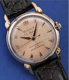 BULOVA HERRENARMBANDUHR AUTOMATIK, SCHWEIZ/ USA UM 1955, WG-FILLED, BODEN EDELST. GESCHR.,GUILL. U. VERS. BLATT, 23 ST., KAL. 10BPAC, SCHR.-UNR., ...