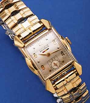 BENRUS HERRENARMBANDUHR, SCHWEIZ/USA UM 1950, GG-FILLED, AUFWEND. RECT.-FORM, SCHEREN-GLIEDERB. SPäTER, KONKAVGL. 3-FLäCHIG, VERS. BLATT FL., ...