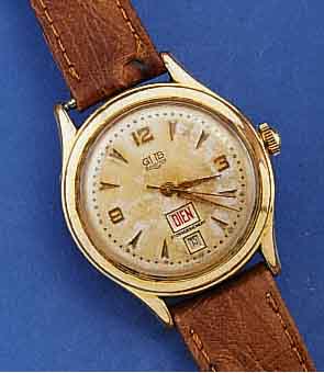 GUB HERRENARMBANDUHR MIT TAG UND DATUM, DEUTSCHLAND 1959, METALL ROTVERG., BER., EDELST.-BODEN GEDR., DATUMSCHNELLKORREKTUR AUßEN 10, AUßER ...
