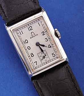 OMEGA HERRENARMBANDUHR, SCHWEIZ UM 1938, EDELST., RECT.-FORM, BODEN GEDR., BLATT M. EMAILL. STD.-ZEICHEN REST., FORMANKERW., 15 ST., KAL. ...